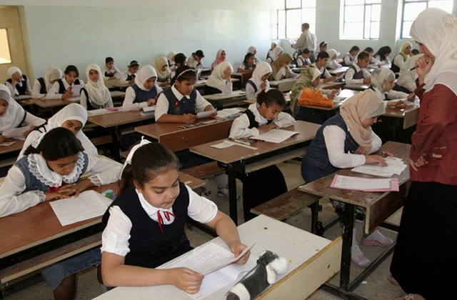 A teacher watches as schoolchildren take their final examinations in Hay al-Masafi primary school in Baiji, 180km (112 miles) north of Baghdad June 4, 2007. Thousands of students across Iraq take their examinations before summer vacation in preparation for their next level of education next school year.   REUTERS/Nuhad Hussin    (IRAQ) - RTR1QFBY